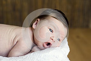 Adorable beautiful newborn baby looking up with a look of wonderment photo