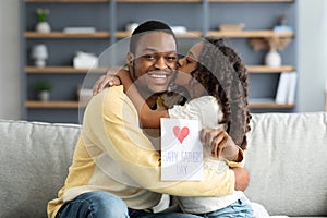 Adorable black girl kissing her dad, Fathers day concept
