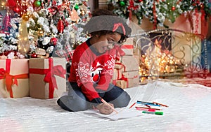 Adorable black little girl writing letter to Santa Claus