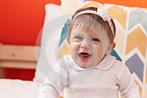 Adorable blonde baby smiling confident sitting on bed at bedroom