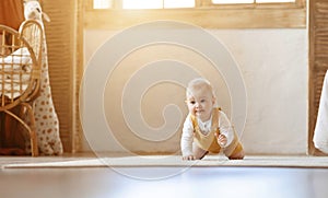 Adorable blonde infant baby crawling by home, copy space