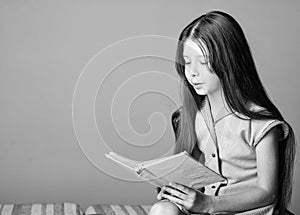 Adorable bookworm. Cute small child reading book on violet background. Little girl learn reading. Home schooling concept
