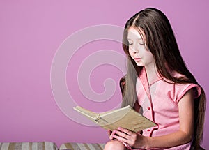 Adorable bookworm. Cute small child reading book on violet background. Little girl learn reading. Home schooling concept