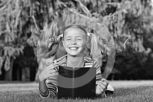 Adorable bookworm. Schoolgirl reading stories relaxing green lawn. Cute pupil enjoy reading. School time. Developing