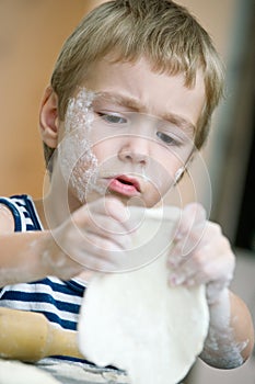 Adorable boy with a face stained with flour