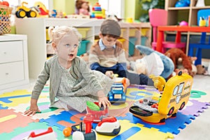 Adorable boy and girl playing supermarket game and with car toys at kindergarten