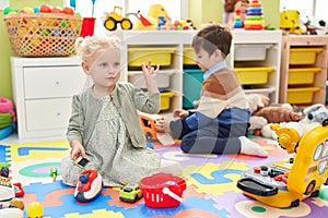 Adorable boy and girl playing supermarket game and with car toys at kindergarten