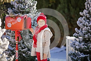 Adorable boy with glasses sending her letter to Santa, Christmas time