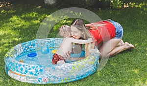 Adorable boy in outdoor swimming pool playing with mother