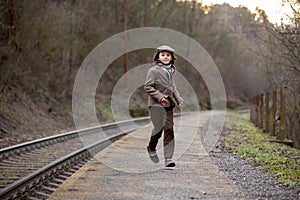 Adorable boy on a railway station, waiting for the train