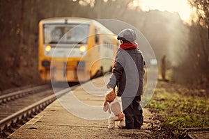 Adorable boy on a railway station, waiting for the train