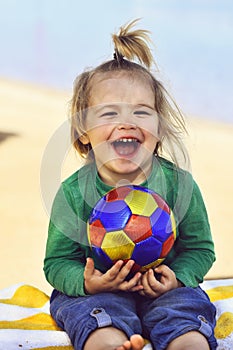Adorable boy small child with happy smiling face holding ball