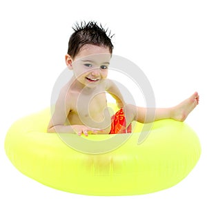 Adorable Boy In Swimsuit Sitting In Green Inner Tube Over White