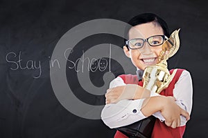 Adorable boy with trophy in class