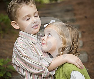 Adorable Brother and Sister Children Hugging Outside