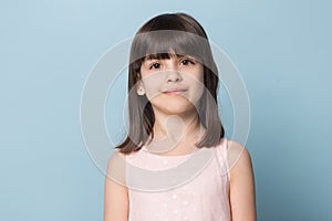 Adorable brown-eyed brown-haired little girl isolated on blue