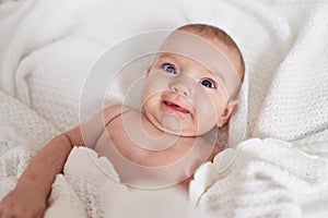 Adorable caucasian baby smiling confident lying on bed at bedroom