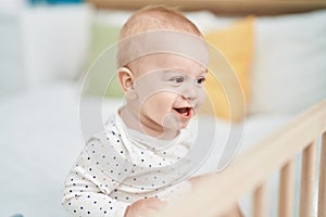 Adorable caucasian baby smiling confident sitting on bed at bedroom