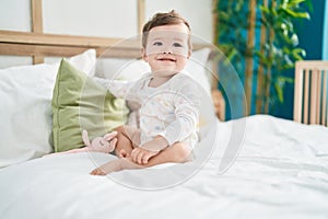 Adorable caucasian baby smiling confident sitting on bed at bedroom