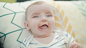 Adorable caucasian baby smiling confident sitting on sofa at home