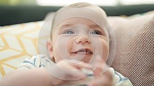 Adorable caucasian baby smiling confident sitting on sofa at home