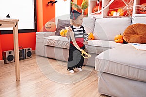 Adorable caucasian boy wearing pirate costume holding sword at home