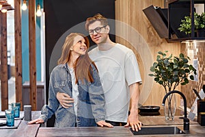 Adorable caucasian couple came to choose interior for future kitchen