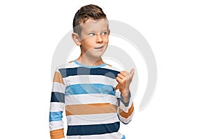 Adorable caucasian kid wearing casual clothes smiling with happy face looking and pointing to the side with thumb up