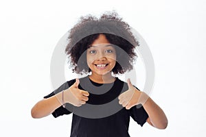 Adorable and cheerful African American kid with afro hairstyle giving thumbs up