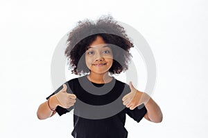 Adorable and cheerful African American kid with afro hairstyle giving thumbs up