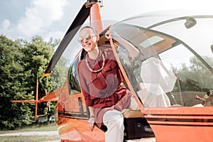 Adorable cheerful woman getting off helicopter