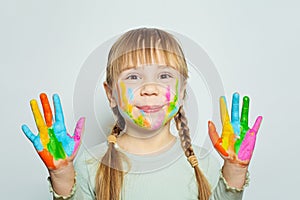 Adorable child with colorful painted hands on white. Happy girl art school student