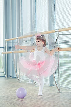 Adorable child dancing classical ballet in studio.