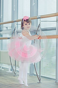 Adorable child dancing classical ballet in studio.