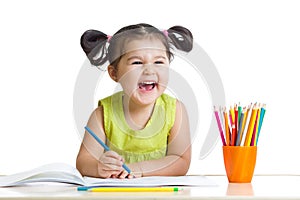 Adorable child drawing with colorful crayons and