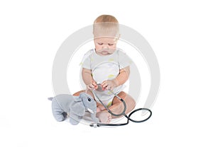 Adorable child dressed as doctor playing with toy