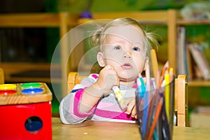 Adorable child girl playing with educational toys in nursery room. Kid in kindergarten in Montessori preschool class.