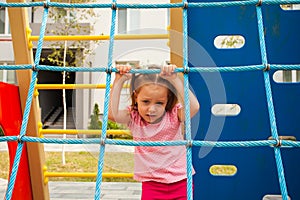 Adorable child girl playing on outdoors playground.