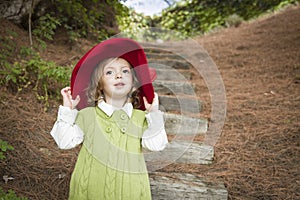 Adorable Child Girl with Red Hat Playing Outside photo