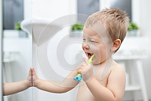 Adorable child learing how to brush his teeth