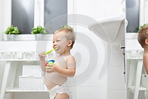 Adorable child learing how to brush his teeth
