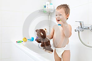 Adorable child learing how to brush his teeth