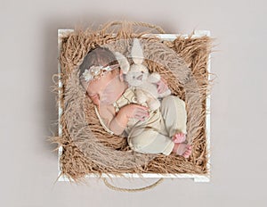 Adorable child napping with rabbit toy, topview