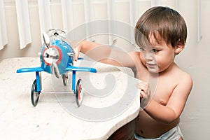 Adorable child playing with toy airplane