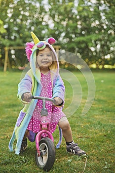 Adorable child riding a bike in the garden