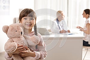 Adorable child with toy and mother visiting doctor