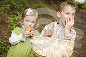 Adorable Children Eating Red Apples Outside