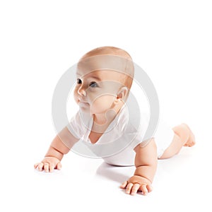 Adorable crawling baby boy looking aside on white