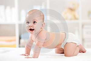 Adorable crawling baby on white blanket
