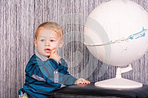 Adorable curious baby boy with a globe